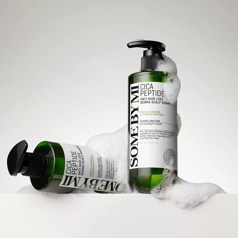 Zwei grüne Shampoo-Flaschen mit Pumpe. Aufschrift: Cica Peptide Anti Hair Loss Derma Scalp Shampoo. Liegen in Schaum.