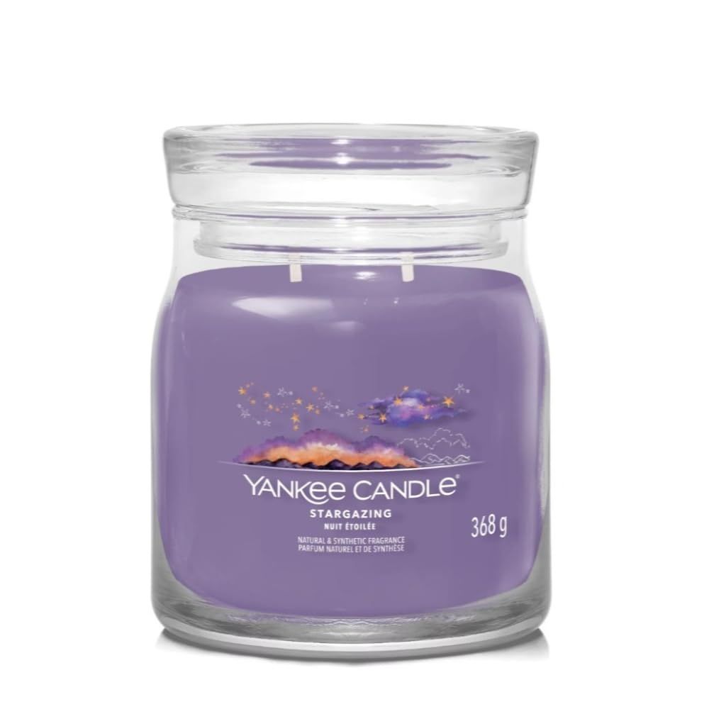 Violette Kerze im Glasbehälter mit Deckel. Aufschrift: Yankee Candle, Stargazing, 368 g. Natürliche und synthetische Duftstoffe.