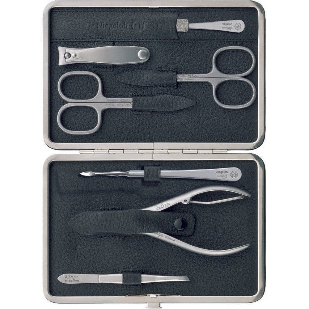 Etui mit sieben Maniküre-Werkzeugen. Enthält Nagelschere, Nagelknipser, Pinzette, Hautschieber und weitere. Schwarzes Lederetui, silberne Werkzeuge.