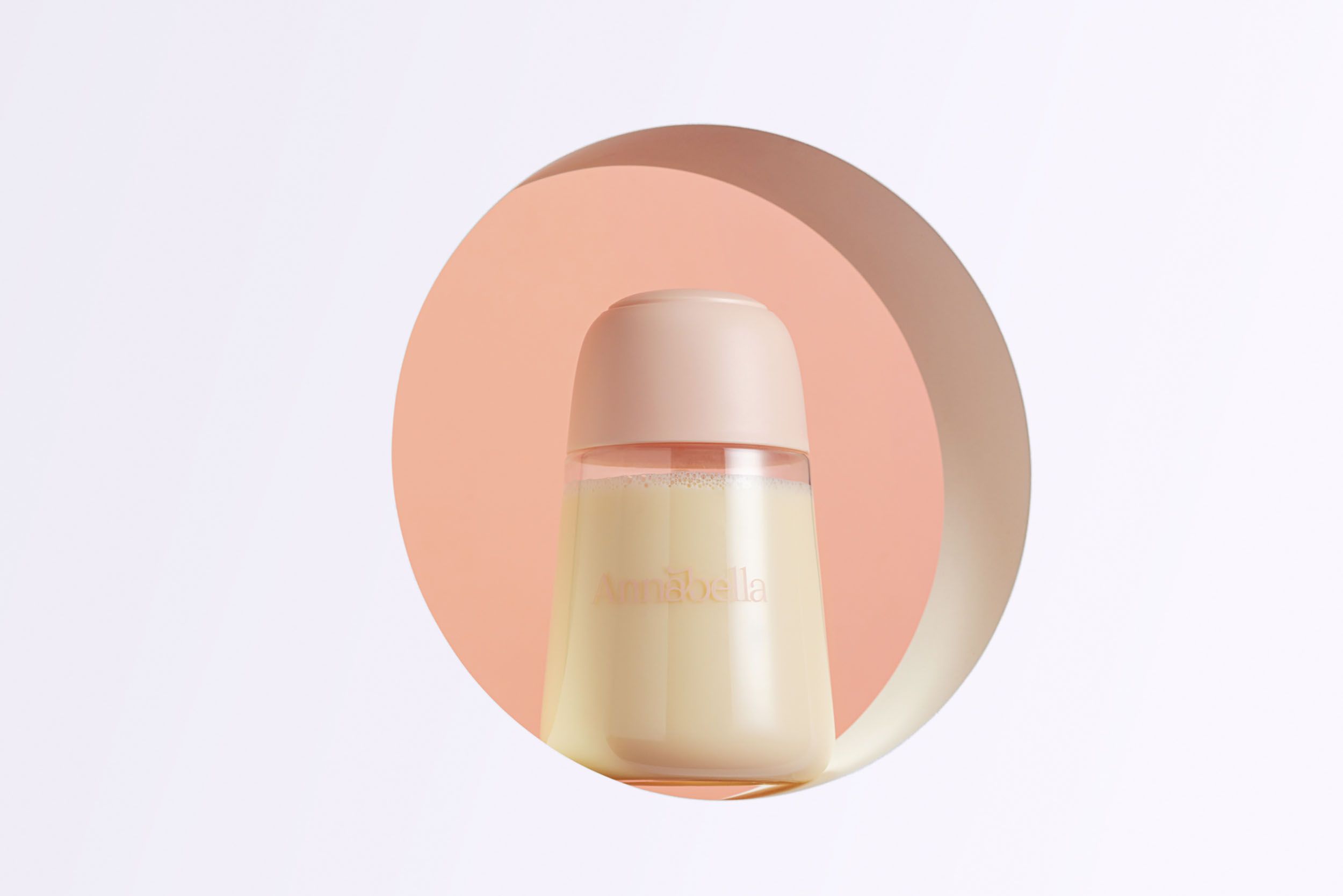 Eine Flasche mit Deckel, gefüllt mit Milch. Skala und Logo "Annabella" sichtbar. In einem kreisförmigen Ausschnitt.