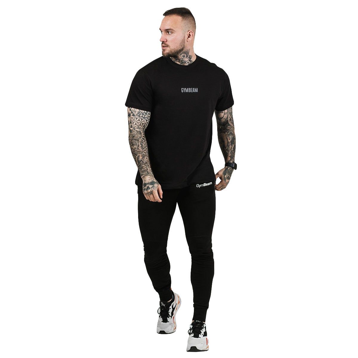 Mann trägt ein schwarzes T-Shirt mit "GYMBEAM"-Logo und schwarze Hose. Weißer Hintergrund.