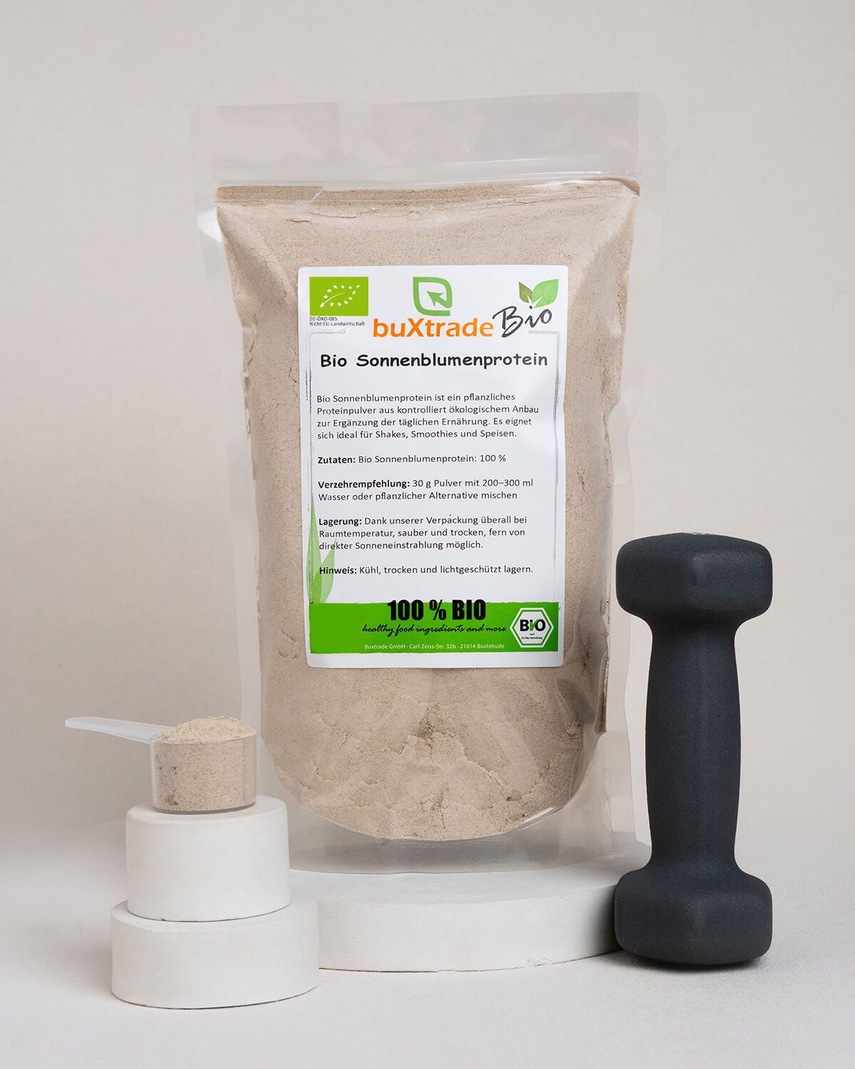 Verpackung buXtrade Bio Sonnenblumenprotein Pulver, Messlöffel, Hantel und Sonnenblumenkerne.