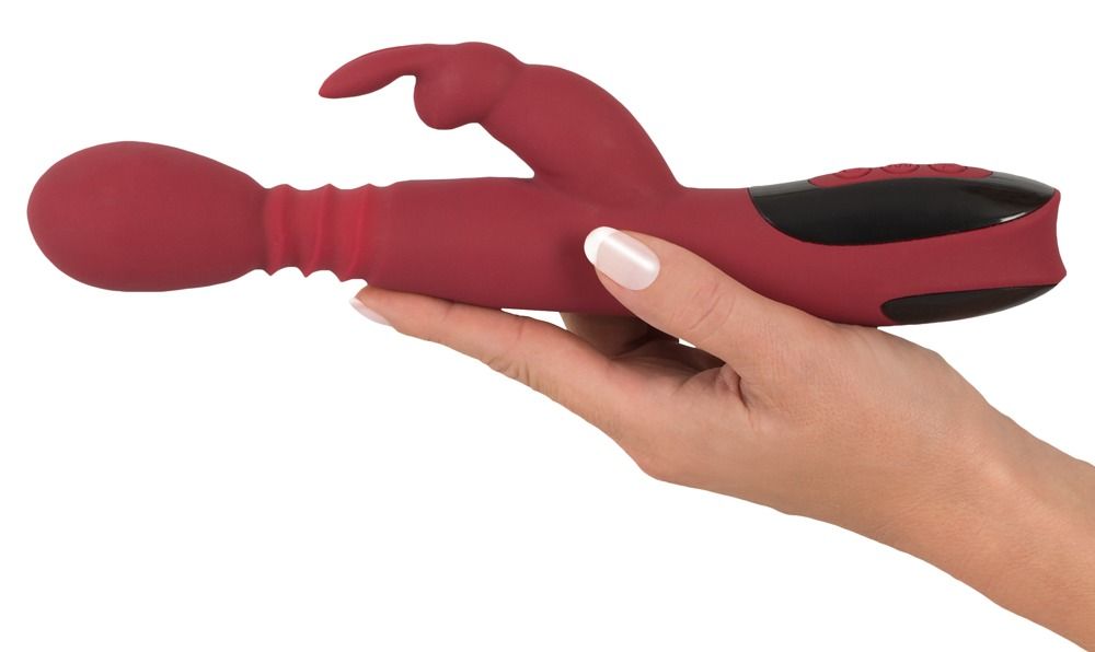 Roter Vibrator mit Kaninchenohren. Von einer Hand gehalten.