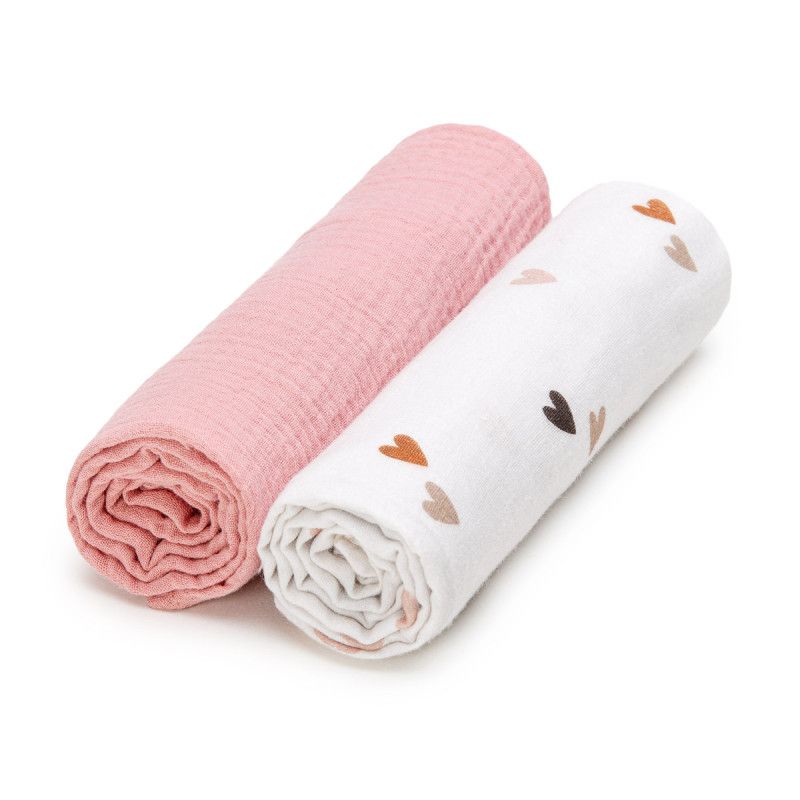 Zwei gerollte Musselin-Windeln. Eine rosa, eine weiße mit braunen Herzen. Baumwollstoff.