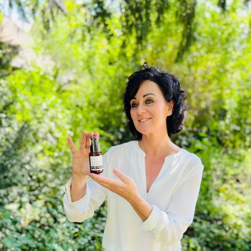 Frau hält Produktflasche. Text: Intense Collagen Booster Serum. Logos: Vegan, IFC Cosmos Organic, Animal Test-Free.