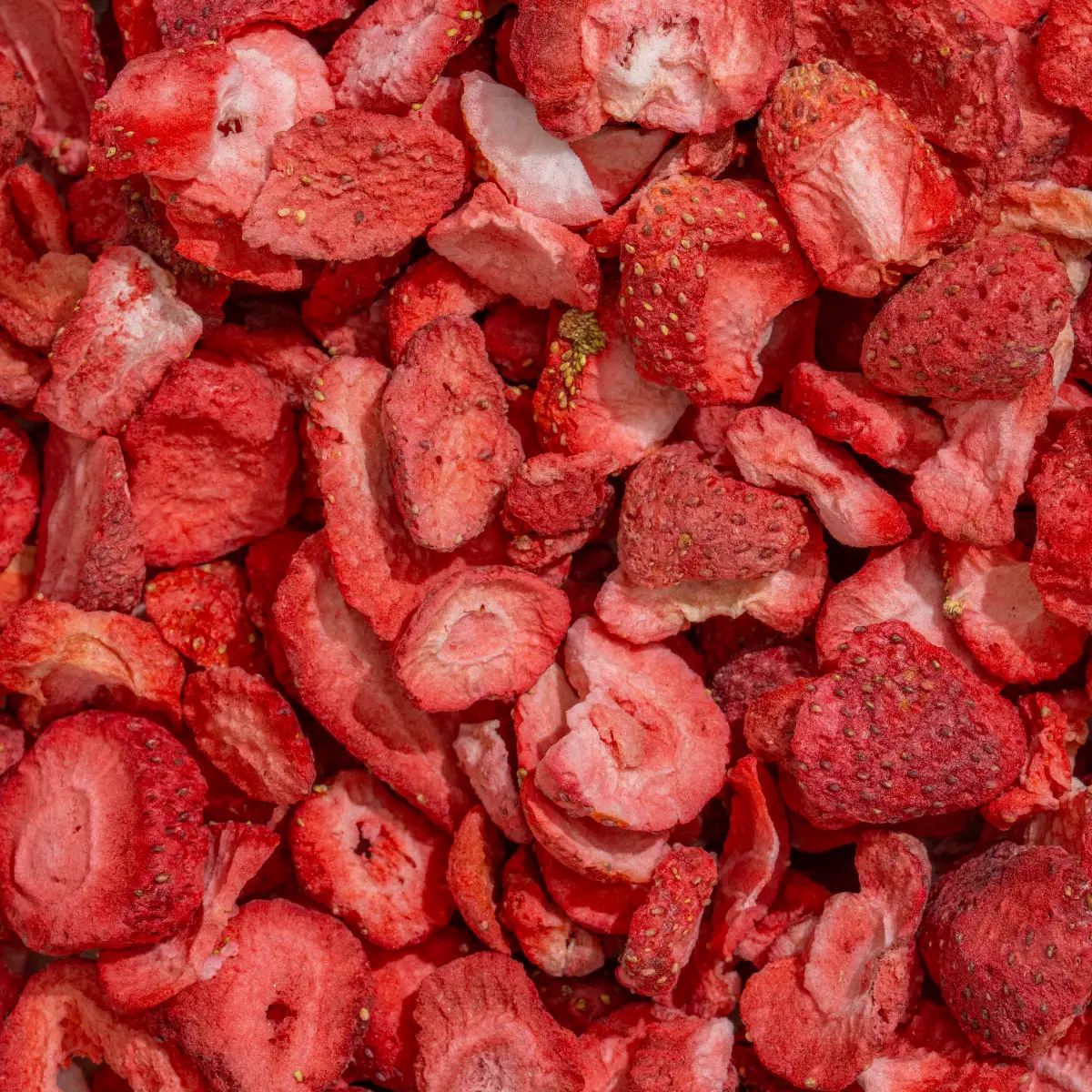 Nahaufnahme von gefriergetrockneten Erdbeerscheiben. Rote Farbe, unregelmäßige Form, unterschiedliche Größen.
