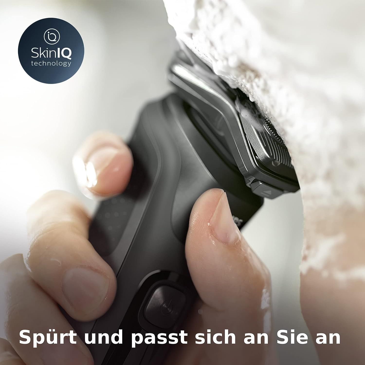 Rasierer in Anwendung mit Schaum. SkinIQ-Technologie-Logo. Text: Spürt und passt sich an Sie an.