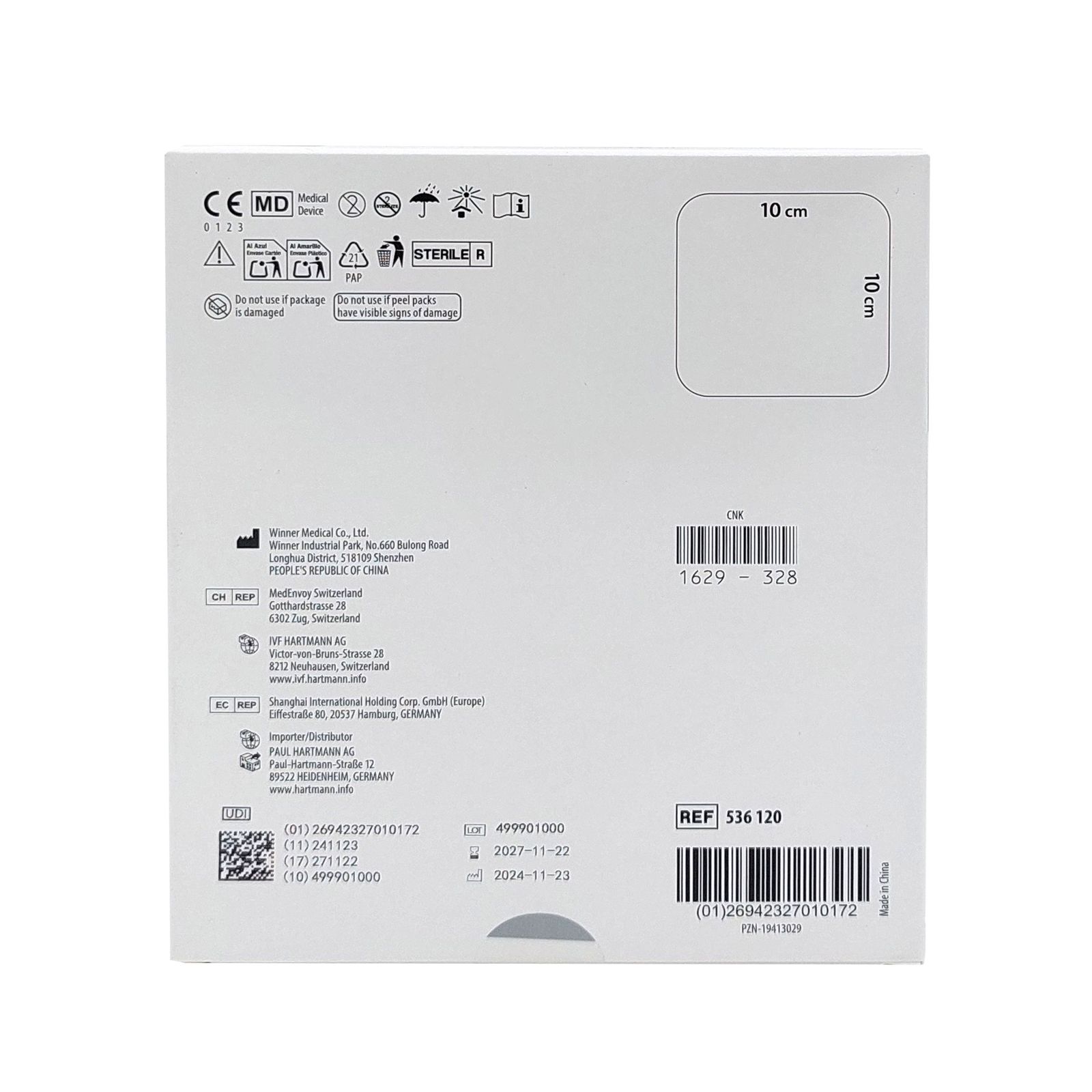 Verpackung mit medizinischen Symbolen, Text und Barcode. Abmessungen 10 x 10 cm. Herstellerinformationen und Chargennummer.