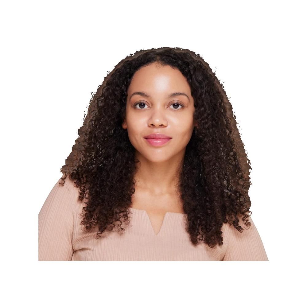 Porträt einer Frau mit lockigem, braunem Haar und einem beigen Oberteil. Sie blickt direkt in die Kamera.