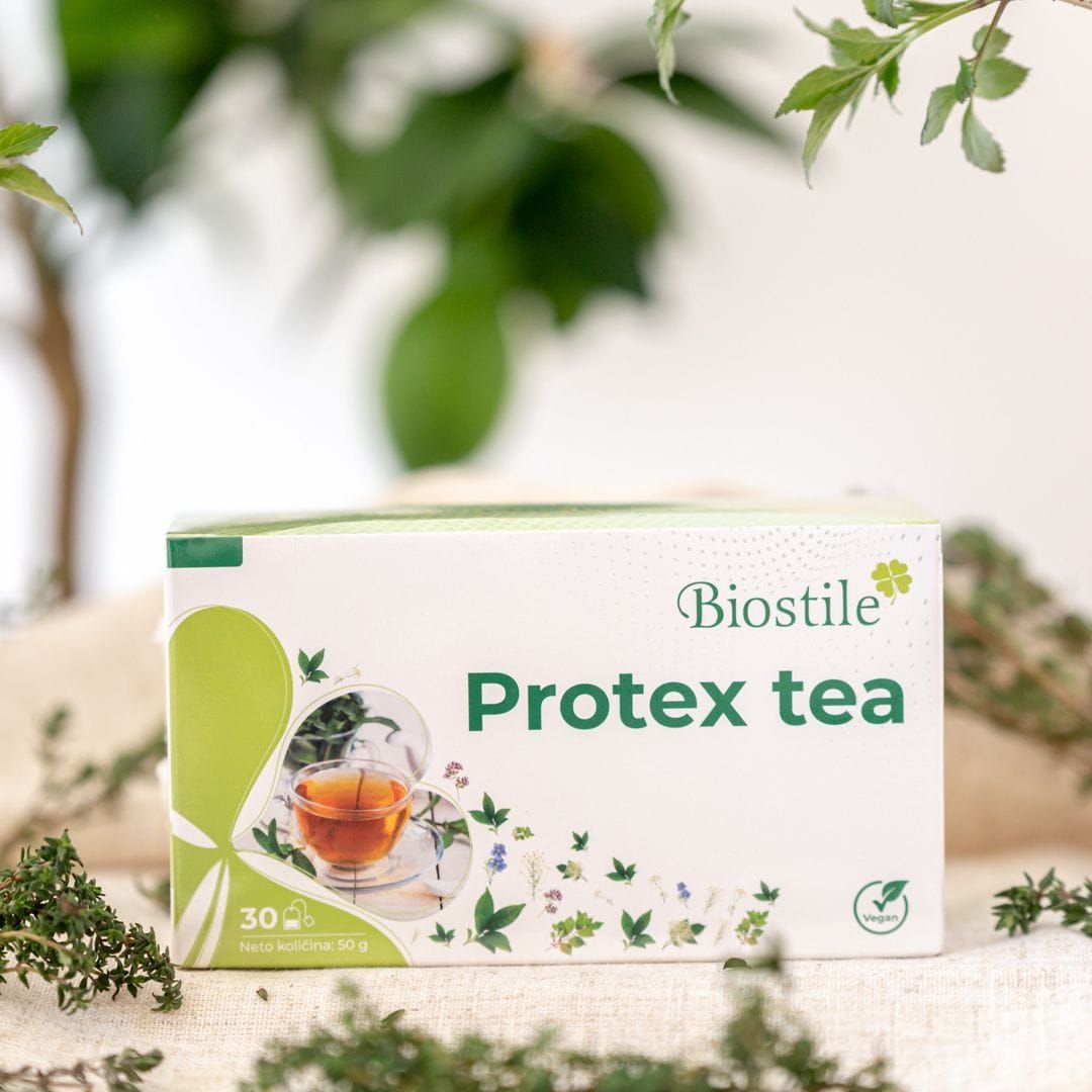 Biostile Protex Tee Kräutertee-Verpackung auf einem Tisch mit Kräutern und Blättern.