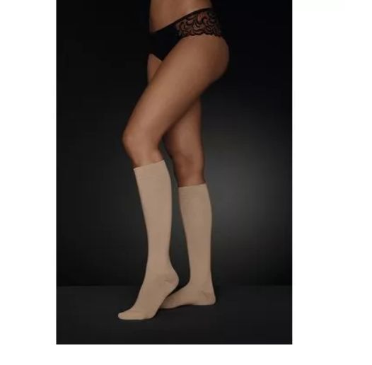 Beige Kompressionsstrümpfe mit offener Fußspitze. Beinansicht. Person trägt Unterwäsche.