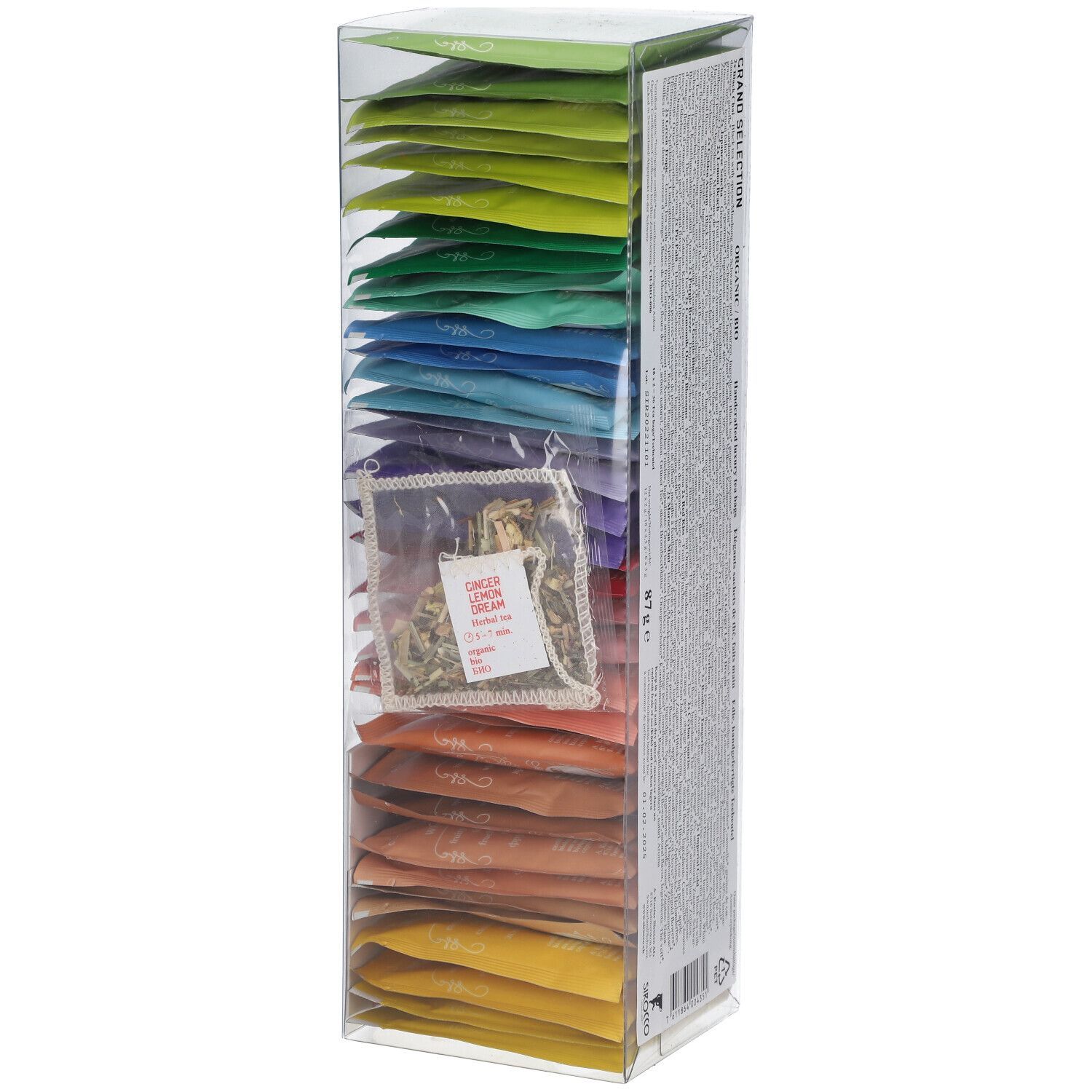 Hohe, transparente Box mit farbigen Teebeuteln. Einzelner Teebeutel sichtbar. Rotes Siegel. Logo auf der Vorderseite.