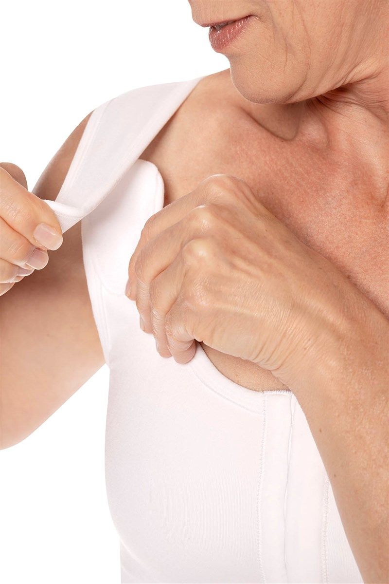 Weißes Oberteil. Schulterpolster werden befestigt. Nahaufnahme.