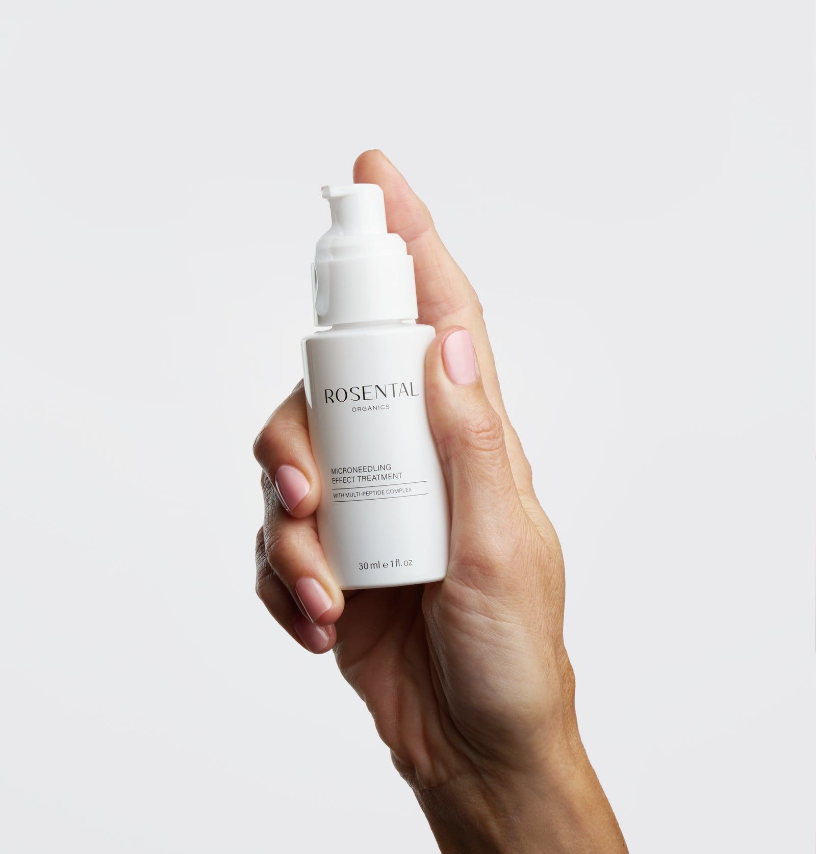 Hand hält eine weiße Flasche mit ROSENTAL Organics-Logo. Produktbezeichnung: Microneedling Effect Treatment.