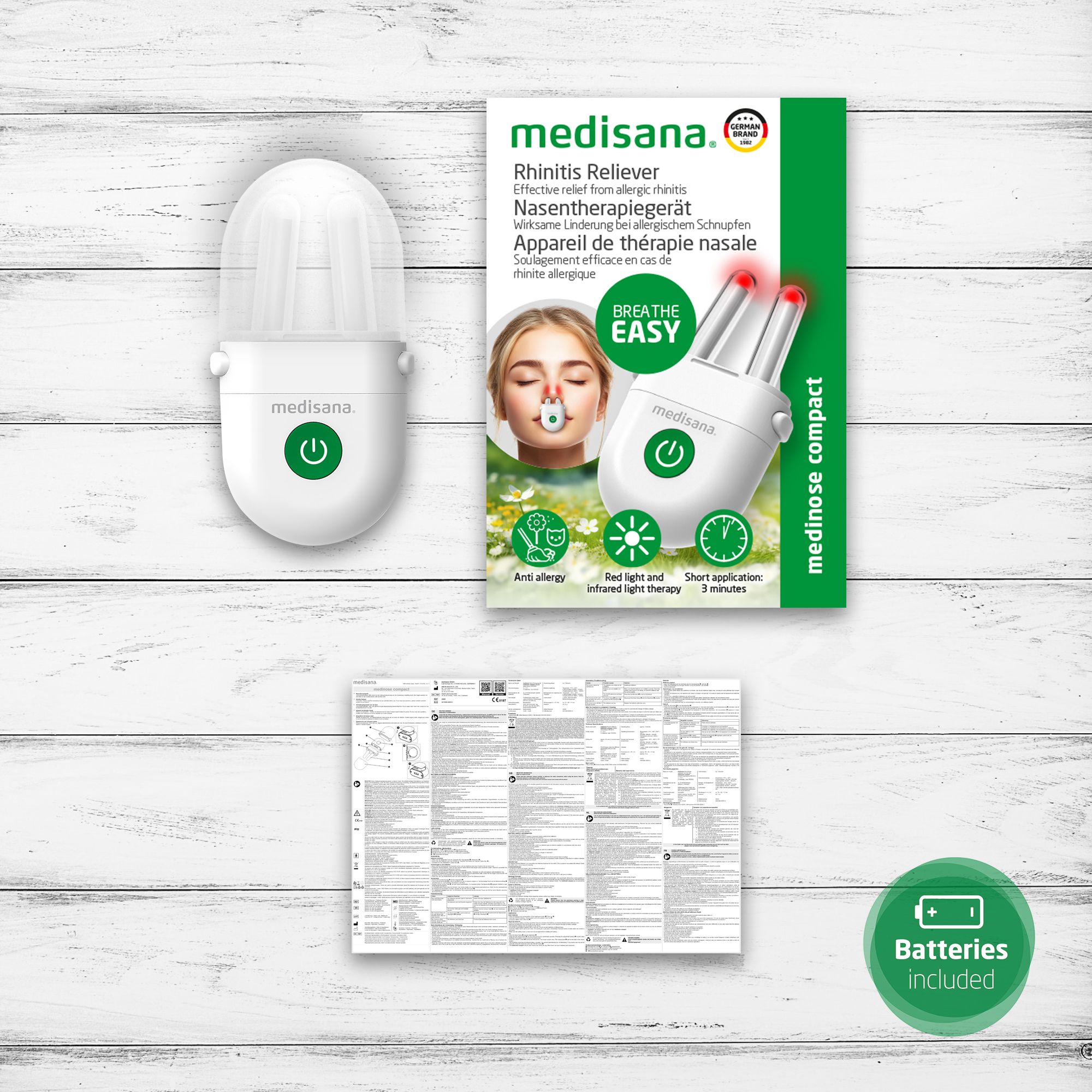 Gerät, Verpackung und Anleitung. Gerät weiß mit grüner Taste. Verpackung mit Produktbild und Text.