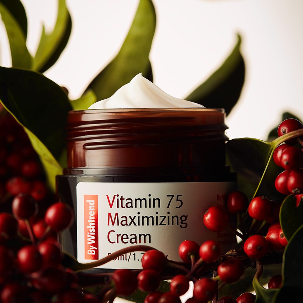 Braunes Glas mit Creme, umgeben von roten Beeren und grünen Blättern. Aufkleber mit roter Schrift: Vitamin 75 Maximizing Cream. Marke: By Wishtrend.