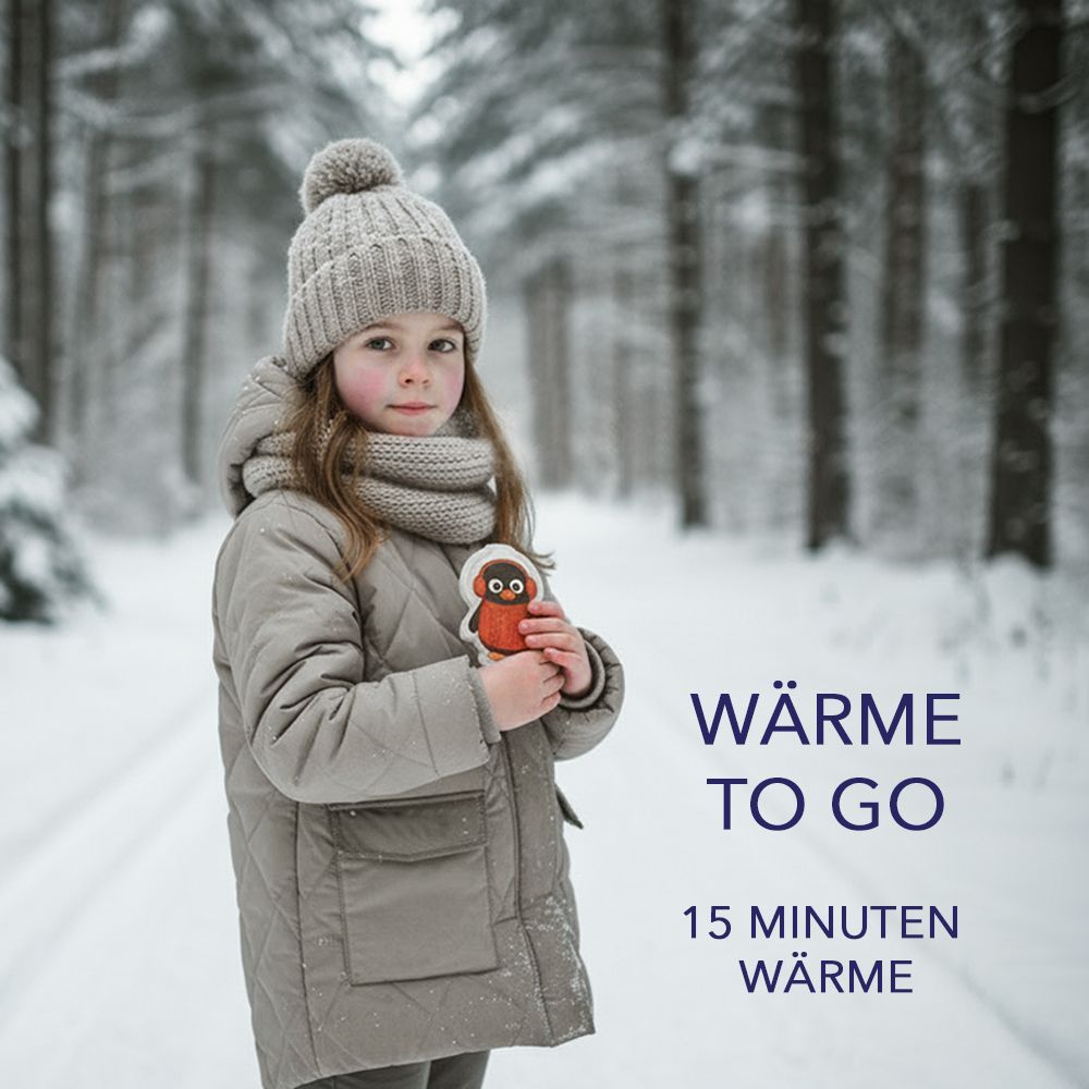 Ein Kind hält einen Handwärmer in Pinguin-Form. Text: Wärme to go, 15 Minuten Wärme. Hintergrund: verschneiter Wald.