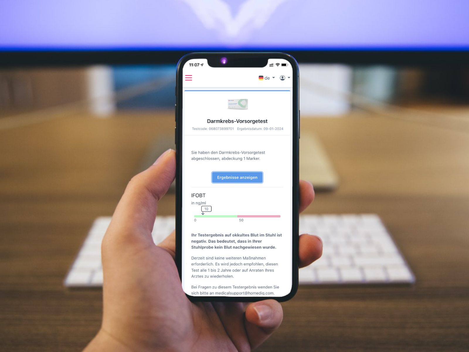 Smartphone mit Ergebnis des Darmkrebs-Vorsorgetests. Anzeige in deutscher Sprache. Helle Anzeige mit grüner Fortschrittsanzeige.