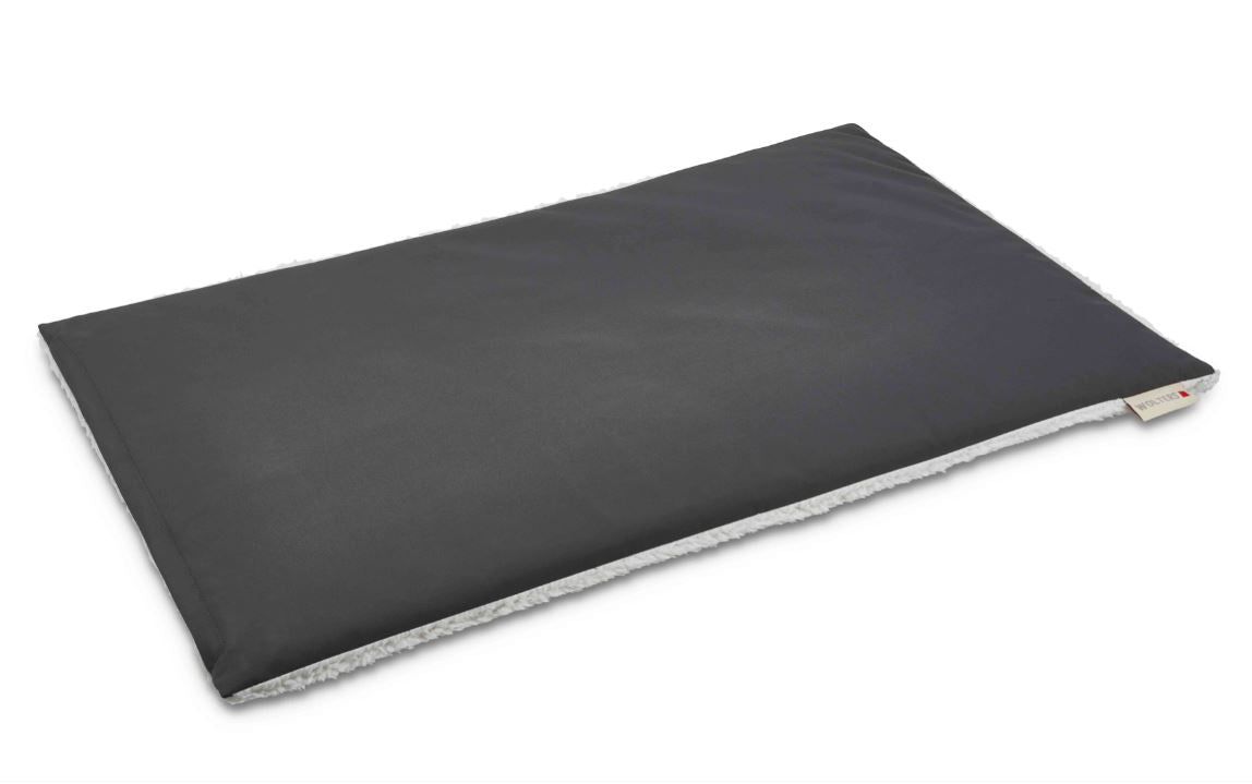 Dunkelgraues, rechteckiges Kissen. Wolters-Label an der Ecke. Größe L: 100 x 65 cm.