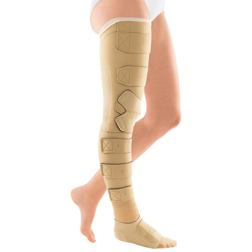 Beige Kompressionsbandage am Bein. Klettverschlüsse und Gurte. Knöchel- und Oberschenkelbereich bedeckt.