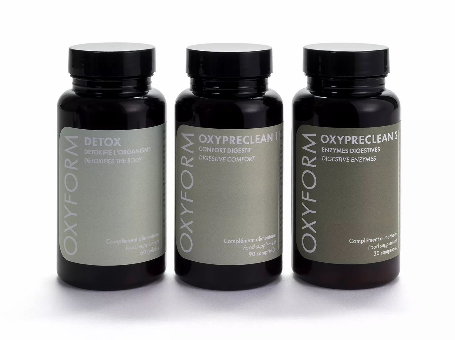 Drei Flaschen mit Etiketten: OXYFORM Detox, OXYPRECLEAN 1 und OXYPRECLEAN 2. Schwarze Deckel und graue Etiketten.