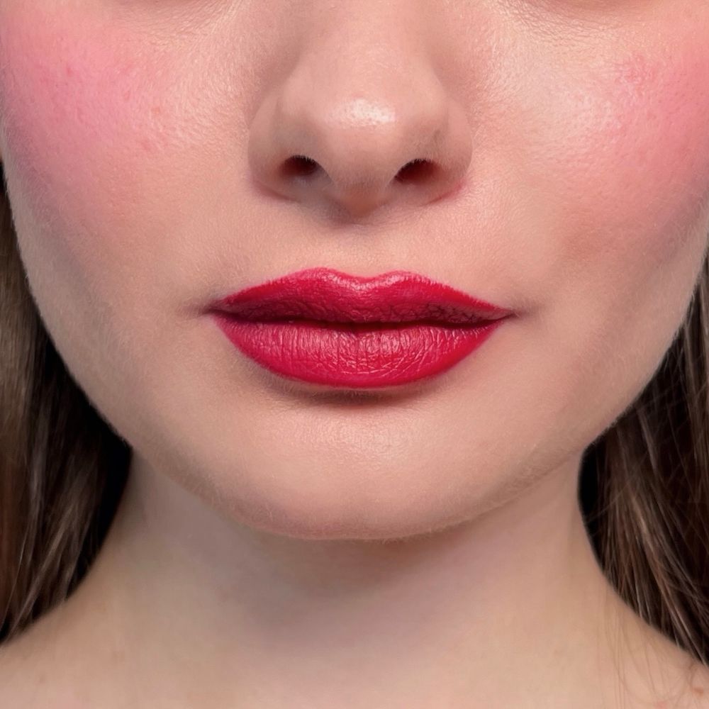 Nahaufnahme von Lippen mit rotem Lippenstift und geröteten Wangen. Hautton.