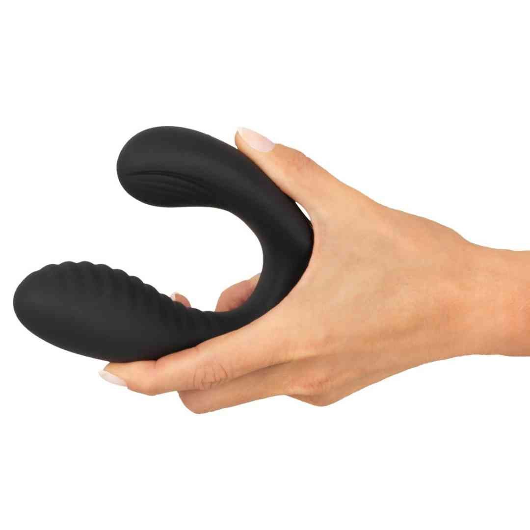 Schwarzer, U-förmiger Plug, geriffelte Oberfläche, in Hand gehalten. Glatte Oberfläche.