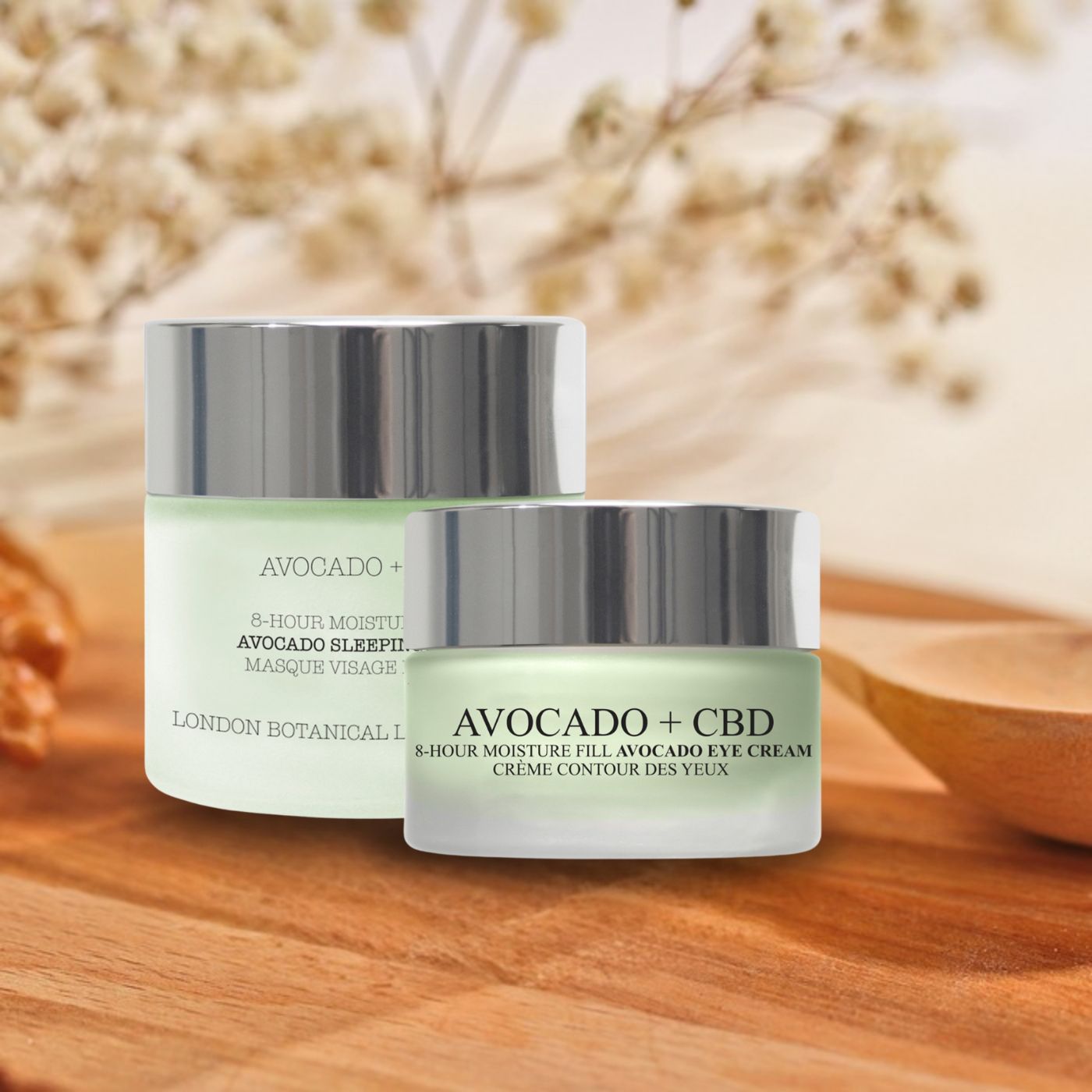 Zwei Glastiegel mit silbernen Deckeln. Text: Avocado + CBD, Avocado Sleeping Mask und Eye Cream. Auf Holzuntergrund.