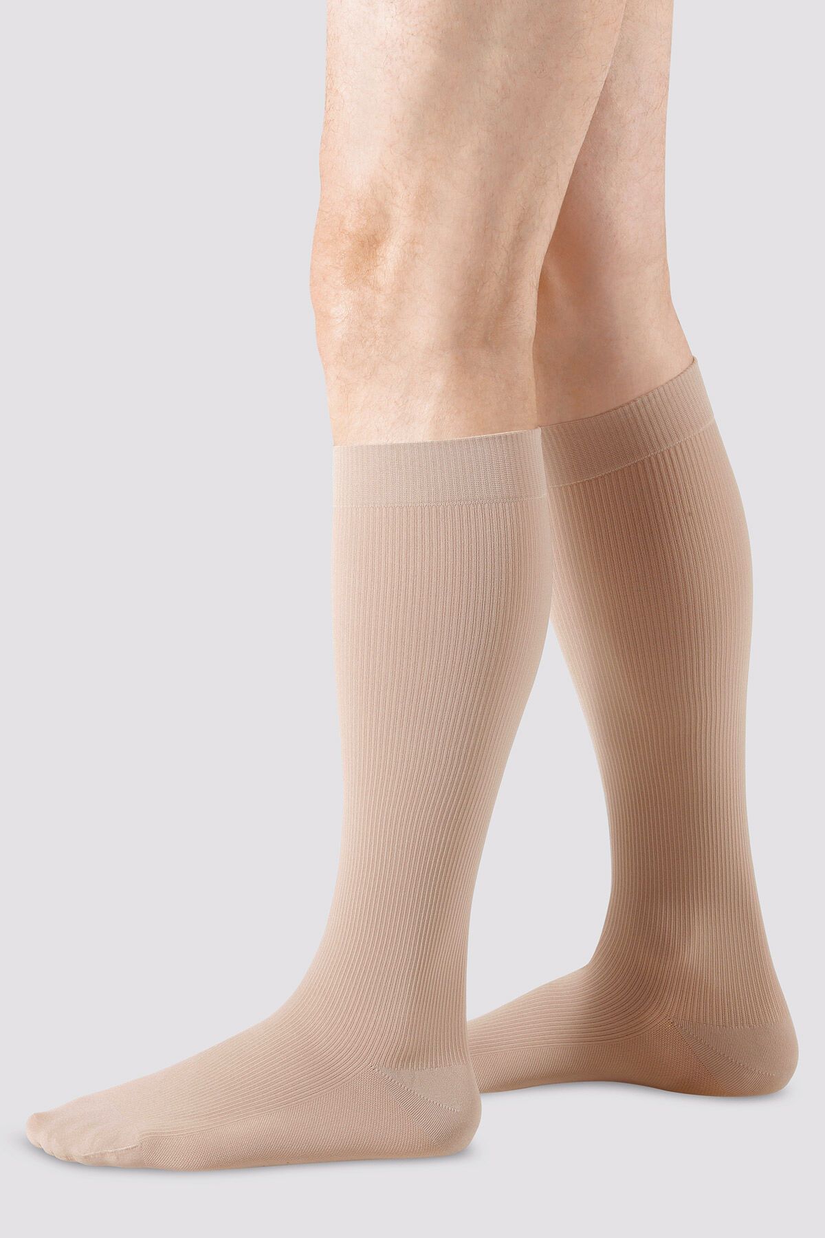 Hautfarbene Kompressionsstrümpfe, gerippt, mit Noppenhaftrand. Auf Beinen getragen.