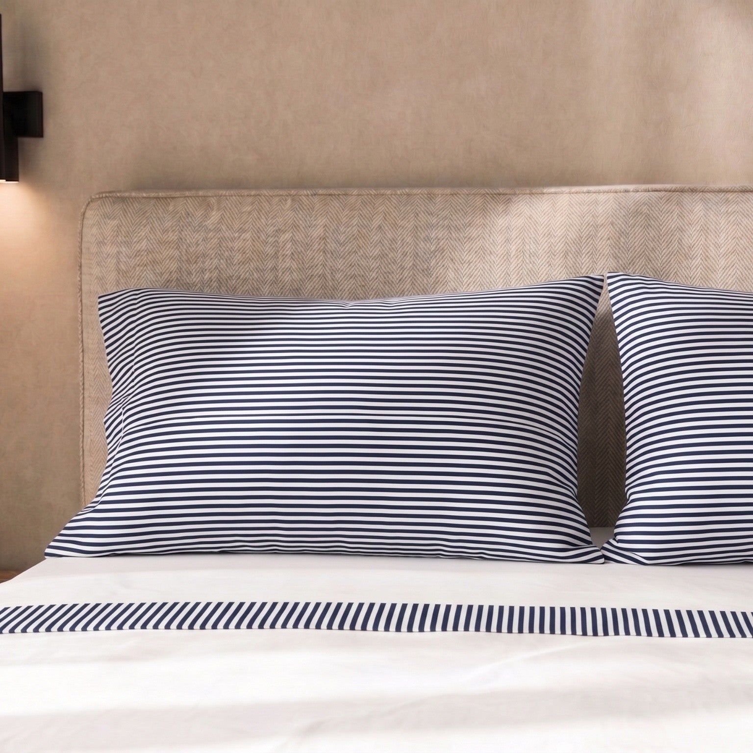 Kissenbezüge mit blau-weißen Streifen auf einem Bett.