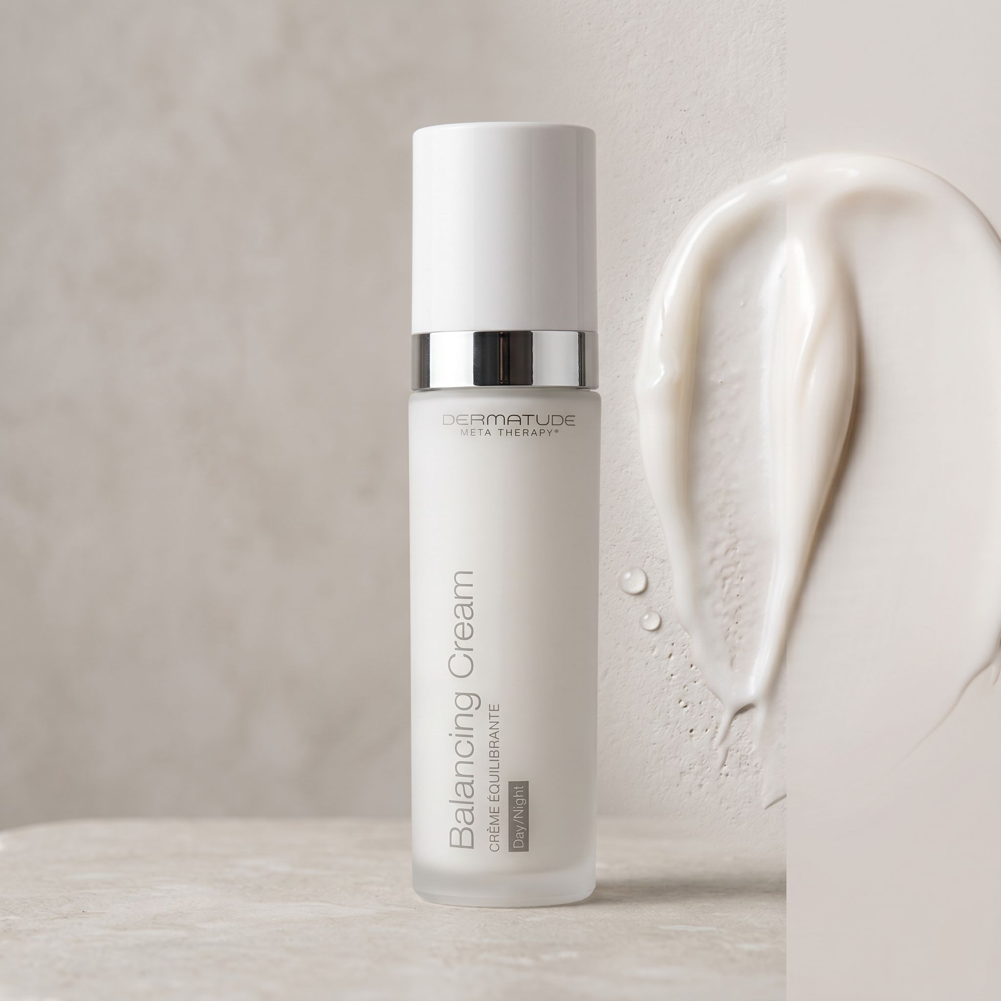 Flasche Balancing Cream mit einem cremigen Tupfer und Wassertropfen.