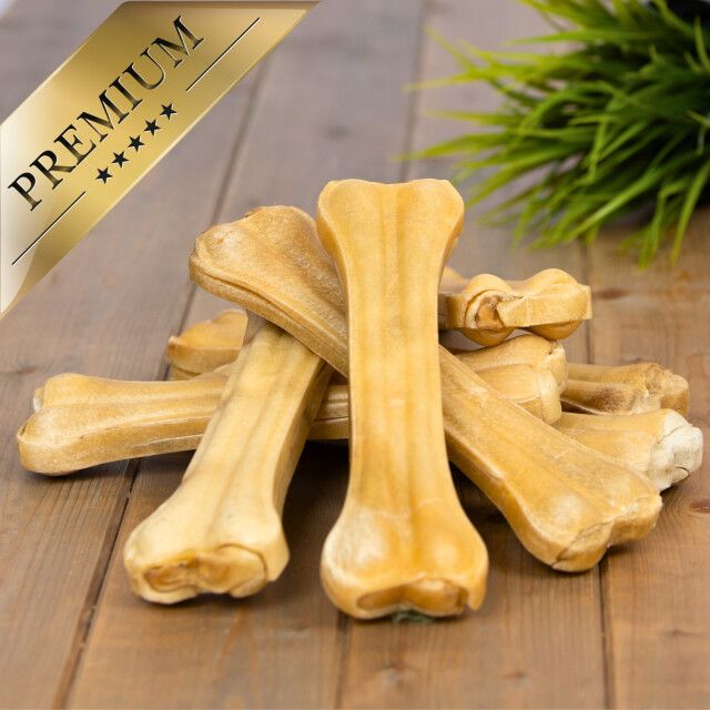 Kauknochen auf Holz. Goldene Aufschrift: PREMIUM. Mehrere Knochen, hellbraun, längliche Form.