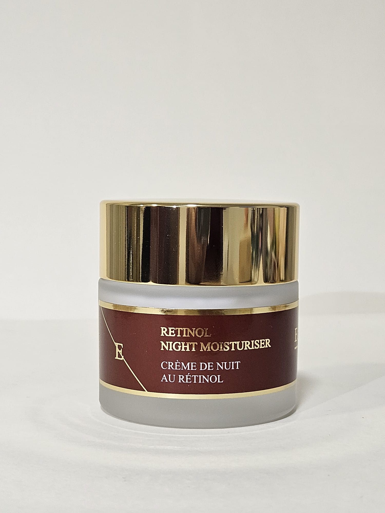 Retinol Nacht-Feuchtigkeitscreme in einem Glasbehälter mit goldenem Deckel. Rotes Etikett. ErthSkin London.