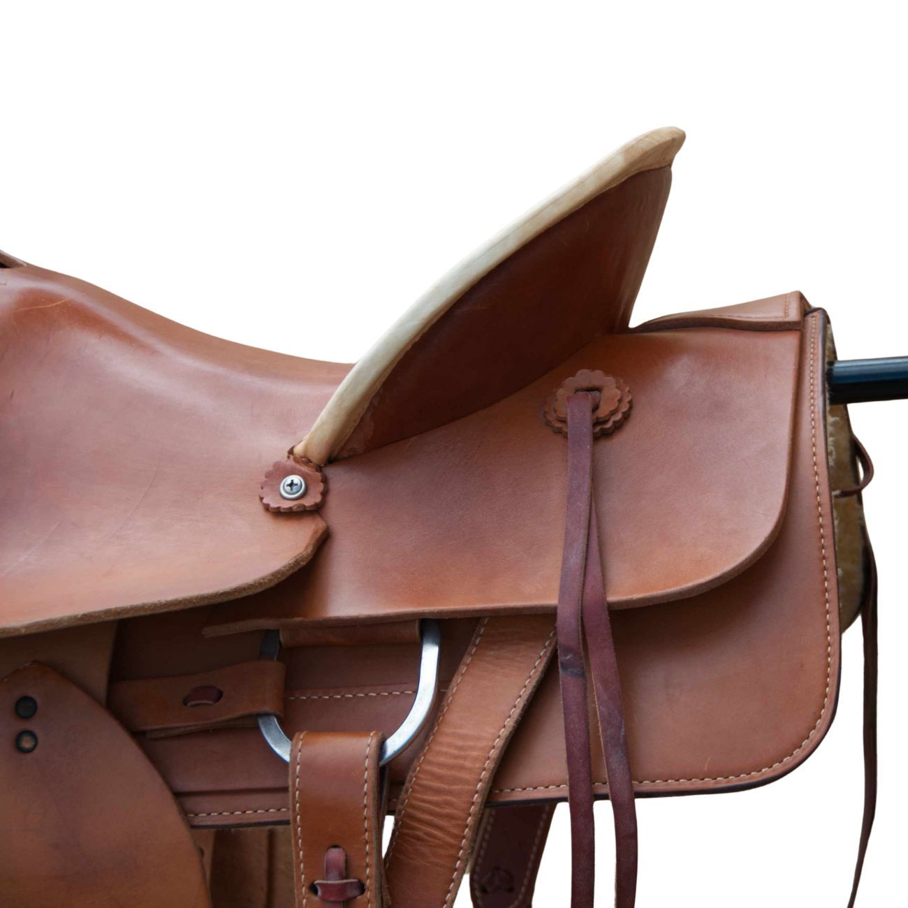 Brauner Westernsattel, Detailansicht. Sattel mit hellem Rand, Lederriemen und Metallbeschlägen. Nahaufnahme, isoliert auf weißem Hintergrund.