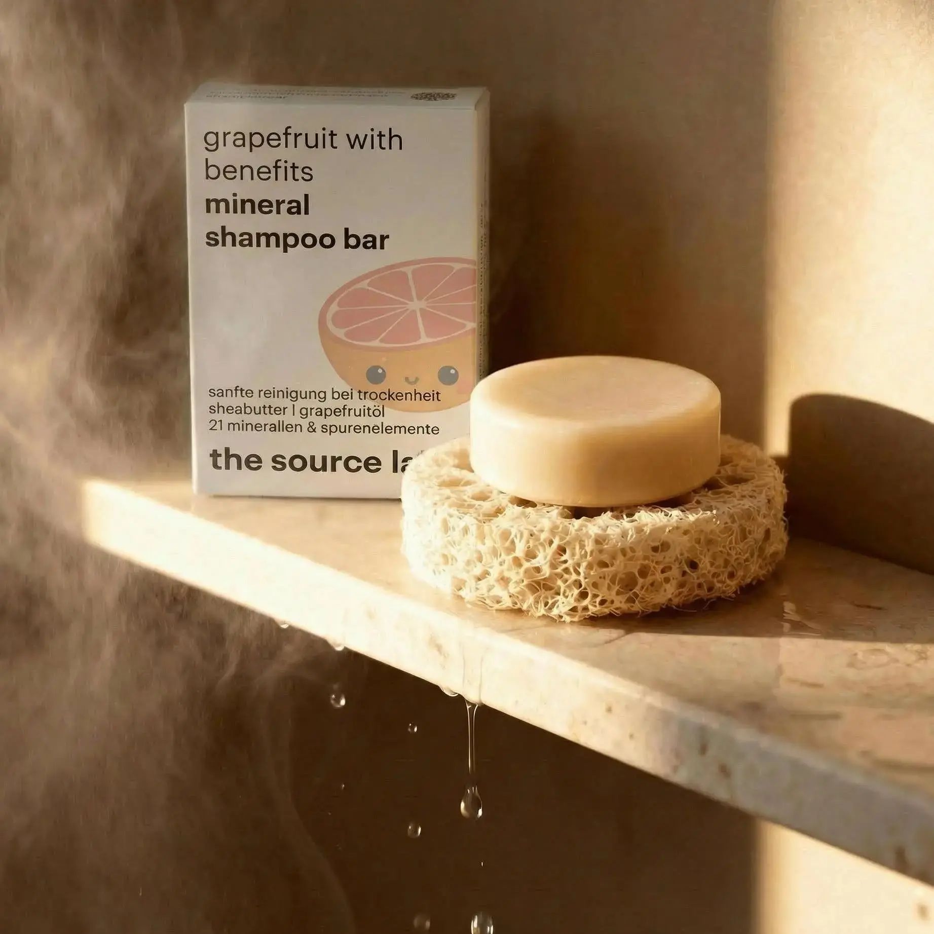 Mineral Shampoo Bar auf einem Schwamm. Verpackung mit Grapefruit-Illustration. Text: grapefruit with benefits mineral shampoo bar. Aufschrift: the source lab.