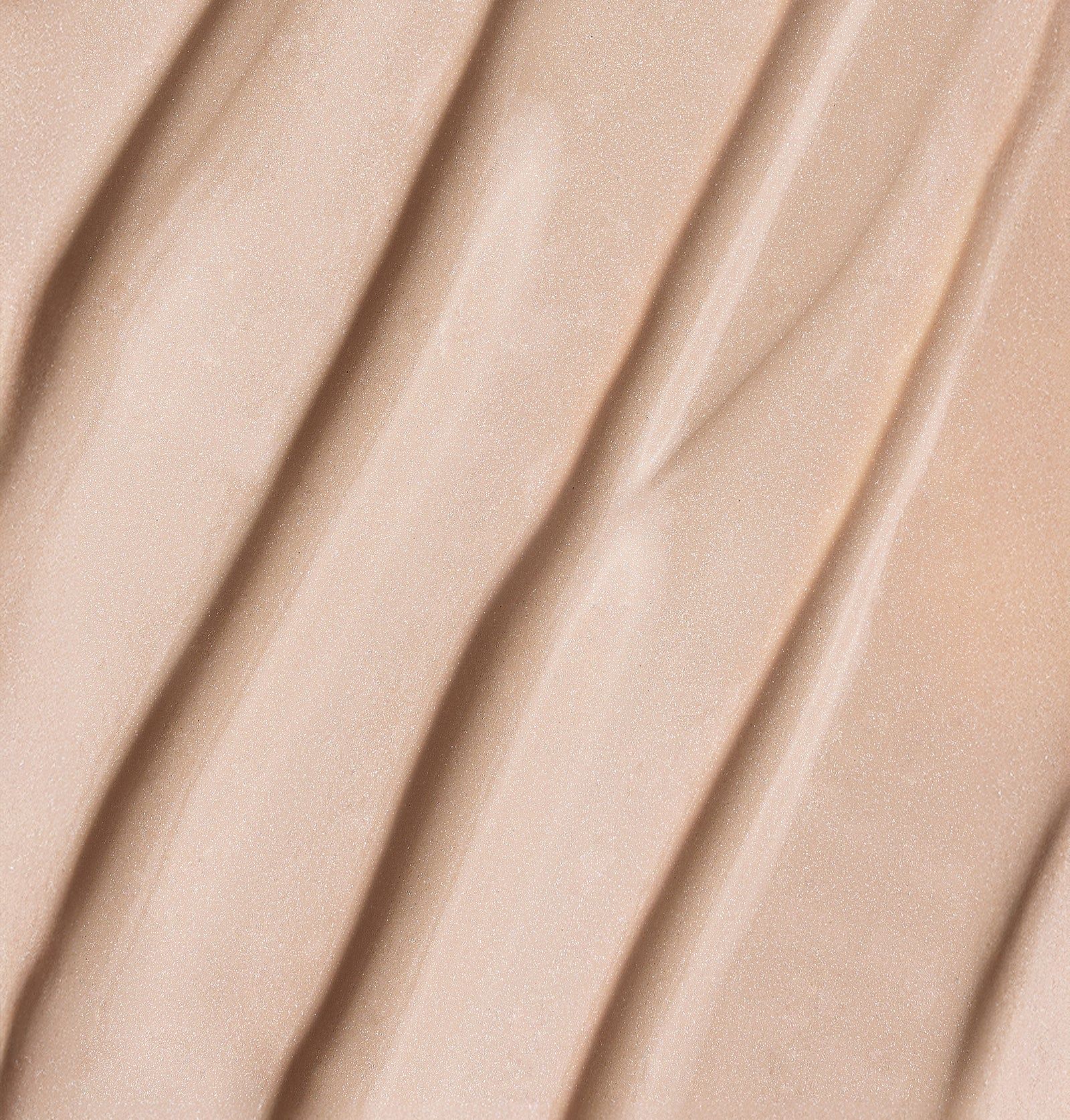 Nahaufnahme von BB Primer. Creme-Textur in wellenförmigen Linien. Helle Farbe.