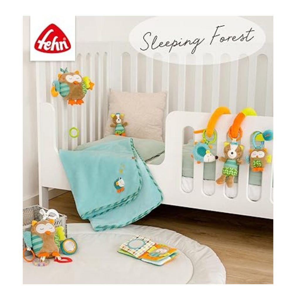 Baby-Spielzeug-Set mit Stoffbuch und Kuscheltieren. Stoffbuch mit Fledermaus-Motiv. Marke: fehn. Auf weißem Bett.