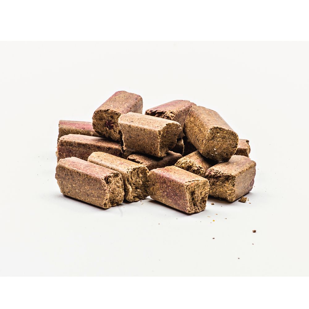 Haufen von rechteckigen, braunen Snacks mit roten Flecken. Auf weißem Hintergrund.