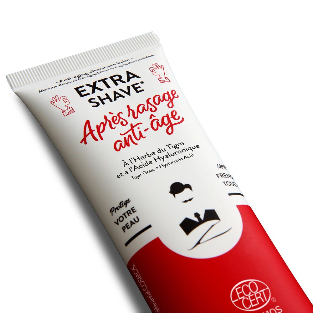 Schräg liegender Tube Monsieur BARBIER Aftershave. Weiß-rotes Design mit Schriftzug 'Extra Shave' und 'Après rasage anti-âge'.