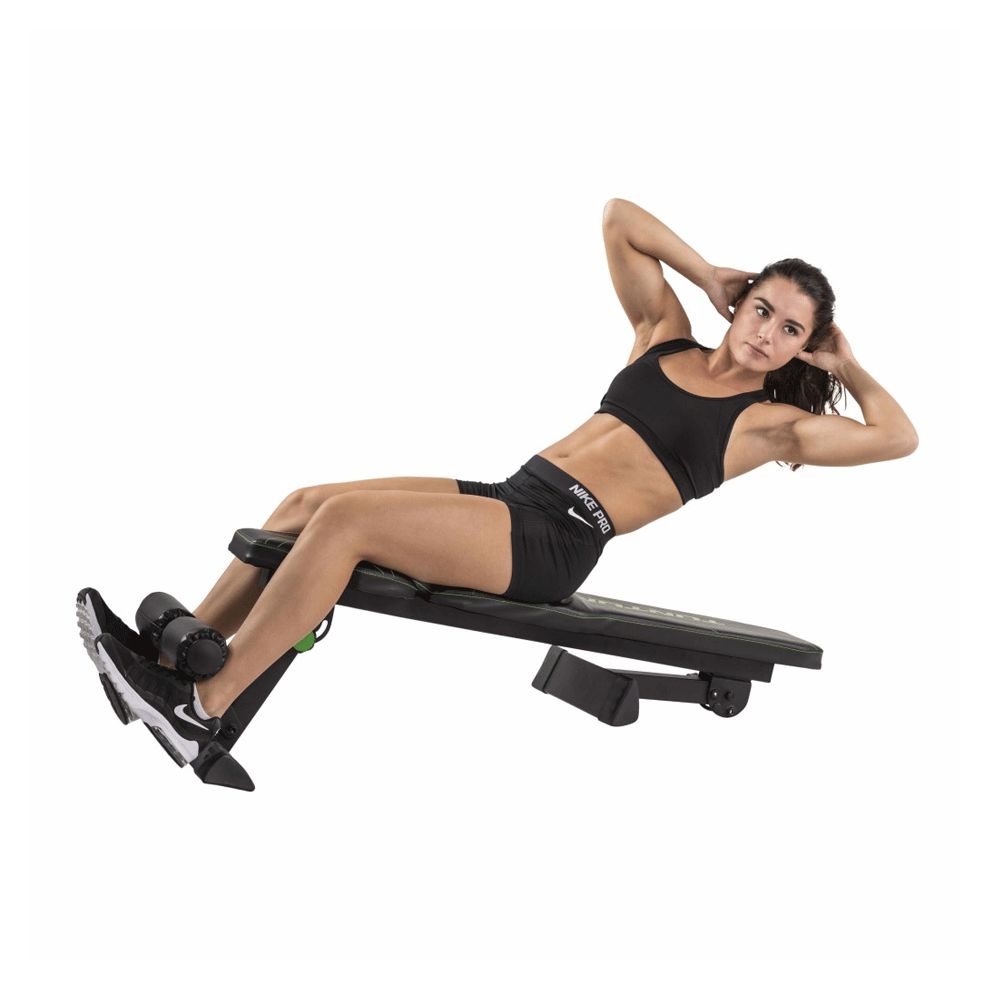 Flachbank mit Frau, die Sit-ups macht. Schwarze Bank mit grünen Akzenten. Frau liegt auf der Bank.