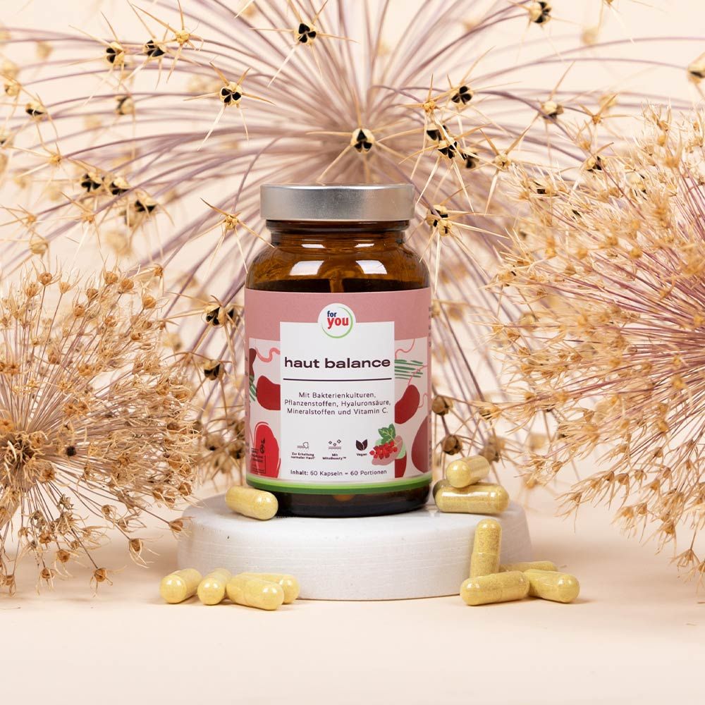 Braunglasflasche mit "for you haut balance" und Kapseln. Hintergrund mit dekorativen Elementen.