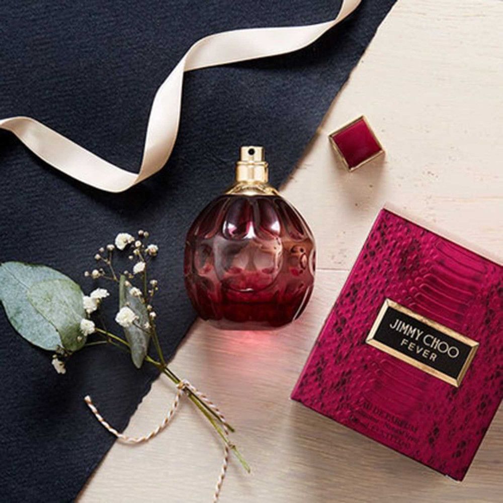 Jimmy Choo Fever Flakon, Deckel und Verpackung. Flakon und Deckel auf Tisch. Verpackung mit Schlangenmuster.