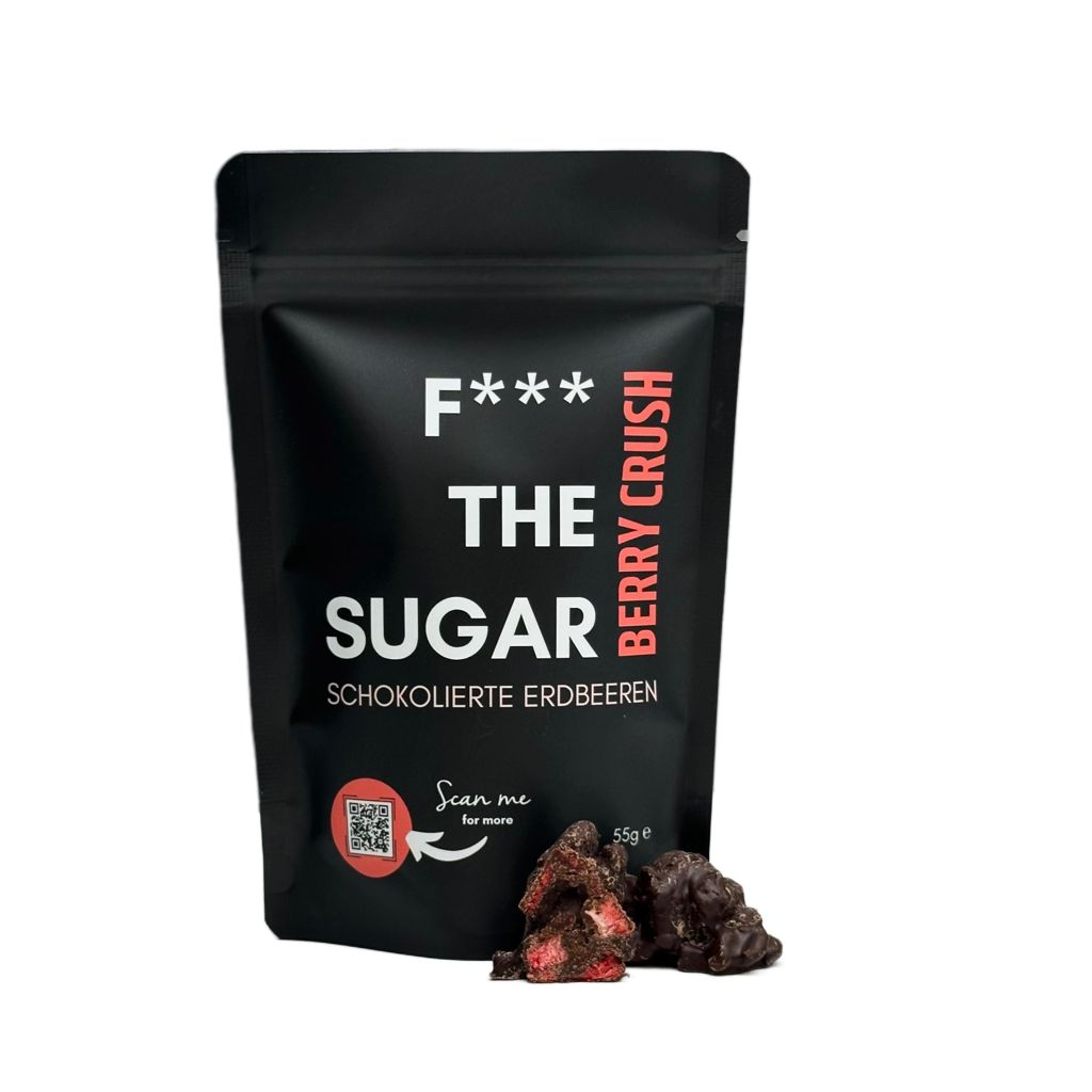 Schwarzer Beutel "F*** THE SUGAR" mit Schoko-Erdbeeren. Aufschrift: Berry Crush. QR-Code. Einige Schoko-Erdbeeren daneben.