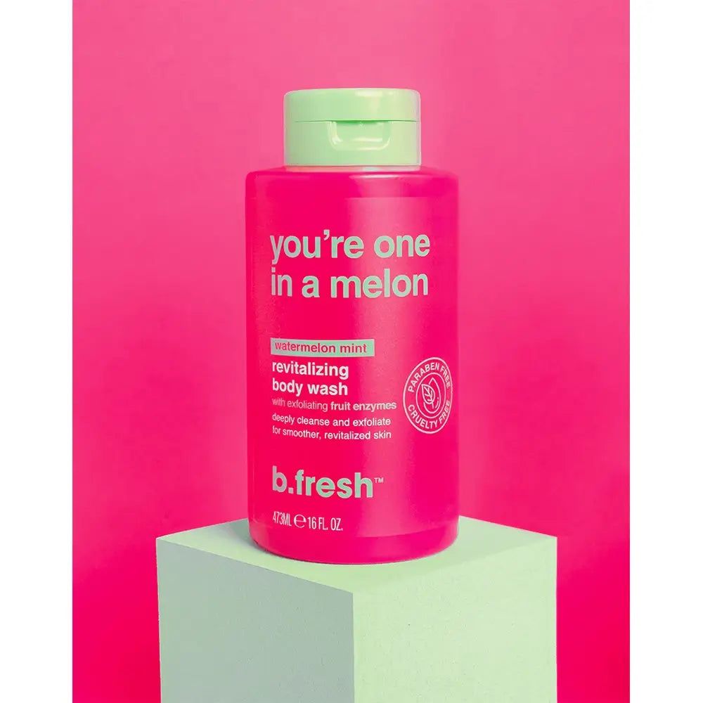 Rosa Duschgelflasche mit grünem Deckel. Aufschrift: "you're one in a melon". Produktname: b.fresh. Steht auf einem grünen Podest.