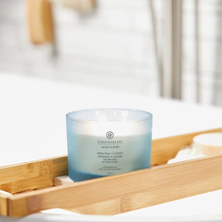 Blaue Kerze Chesapeake Bay, mind & body, reflection + clarity, auf Holzablage. Badezimmer-Kontext.