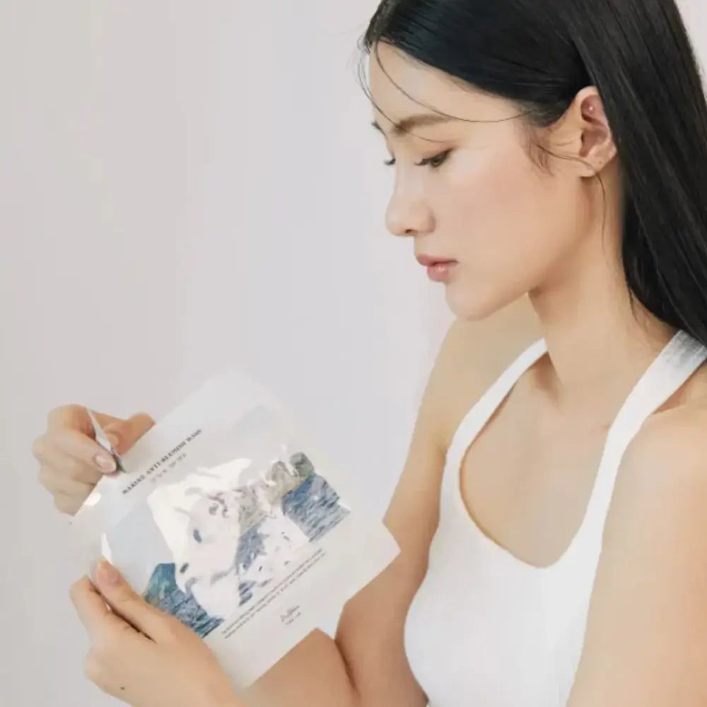 Frau hält eine Gesichtsmaske. Maske mit Landschaftsmotiv. Text: Marine Anti-Blemish Mask. Marke: Dr. Althea.