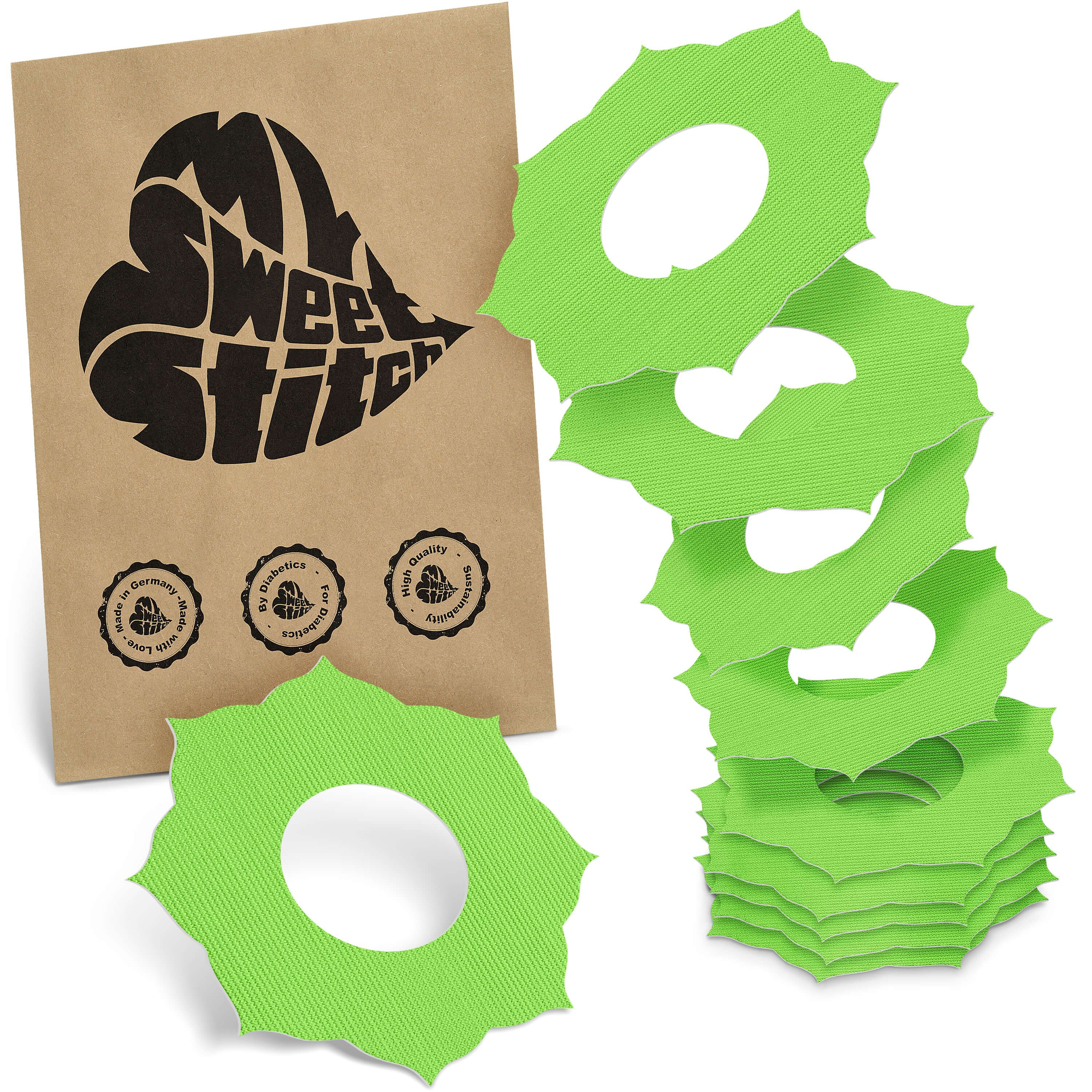 Grüne, blütenförmige Fixierringe mit zentraler Öffnung. Neben einer Papiertüte mit Logo und Qualitätssiegeln.