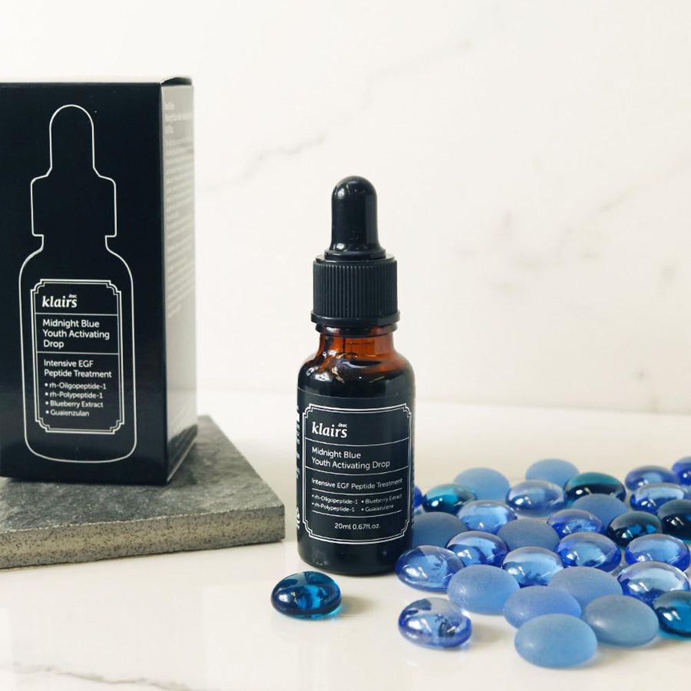 Braune Glasflasche mit schwarzem Deckel. Auf dem Etikett steht "Midnight Blue Youth Activating Drop".
