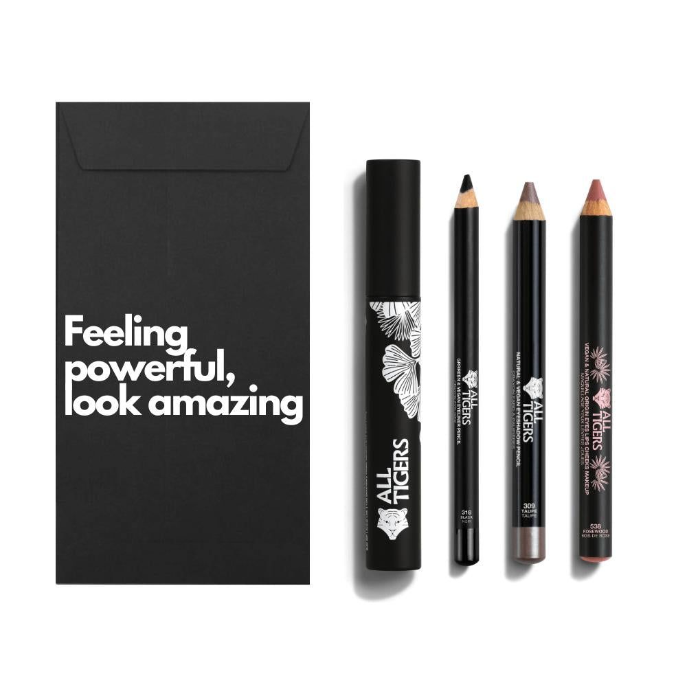 Schwarze Geschenkbox mit Text. Daneben Mascara, zwei Stifte und ein Lippenstift. Alle Produkte tragen das Logo.