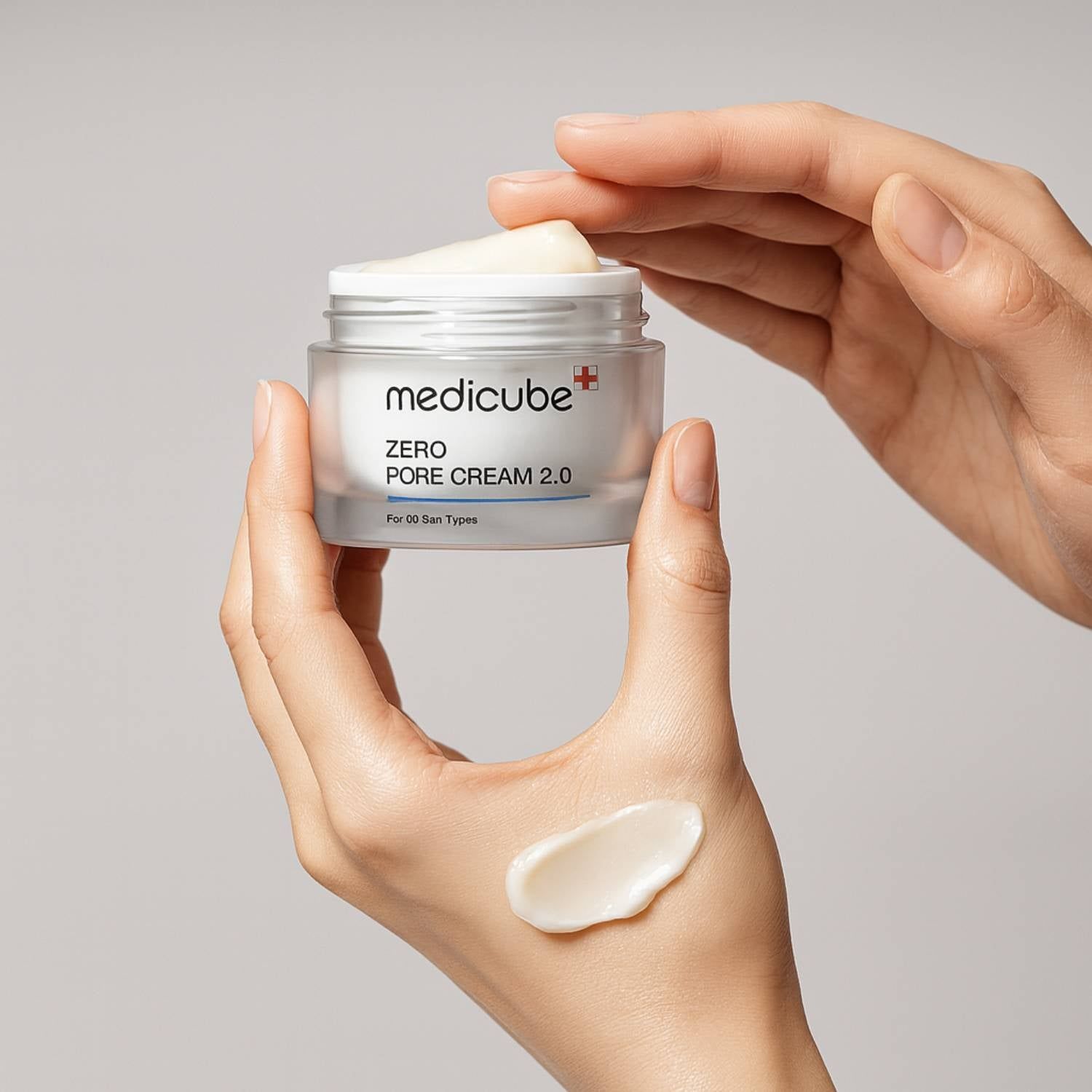 Hände halten MEDICUBE Zero Pore Cream 2.0 Tiegel. Cremeprobe auf Handfläche.